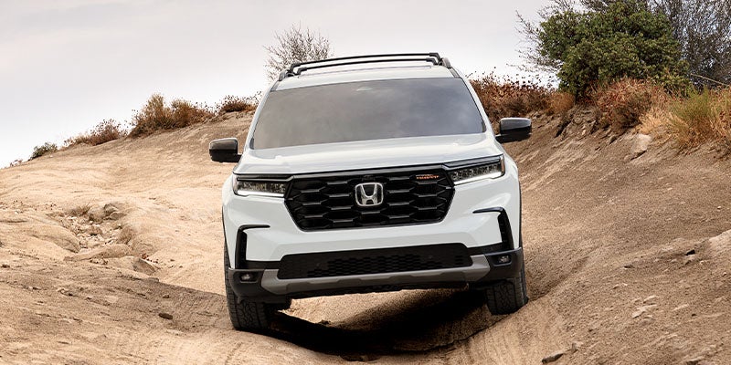 A photo of a white 2025 Honda Pilot off-roading